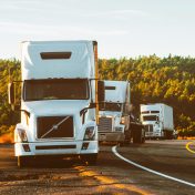 pexels-photo-2199293-2199293 Three semi trucks driving on a highway through a forested landscape in Arizona.